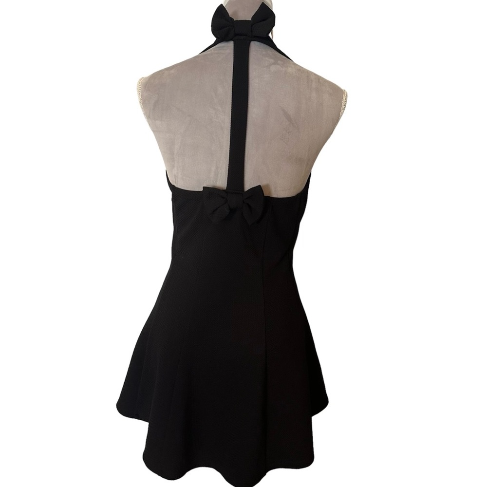 Black halter A line top with bow detail in back. Hi low hem line. Unique. Size L